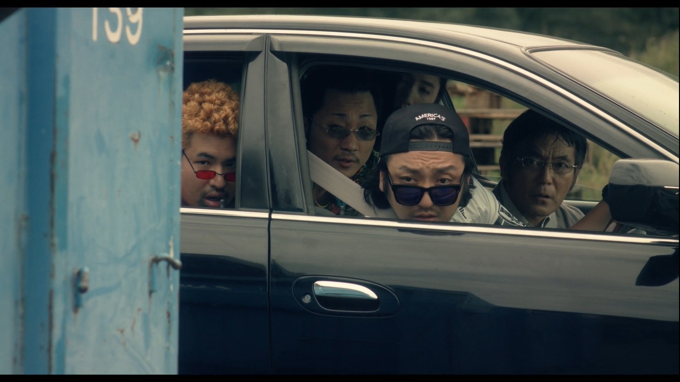 車の中から5人で睨んでいる中に写るパンチパーマにサングラス姿の榎本桜さんの写真