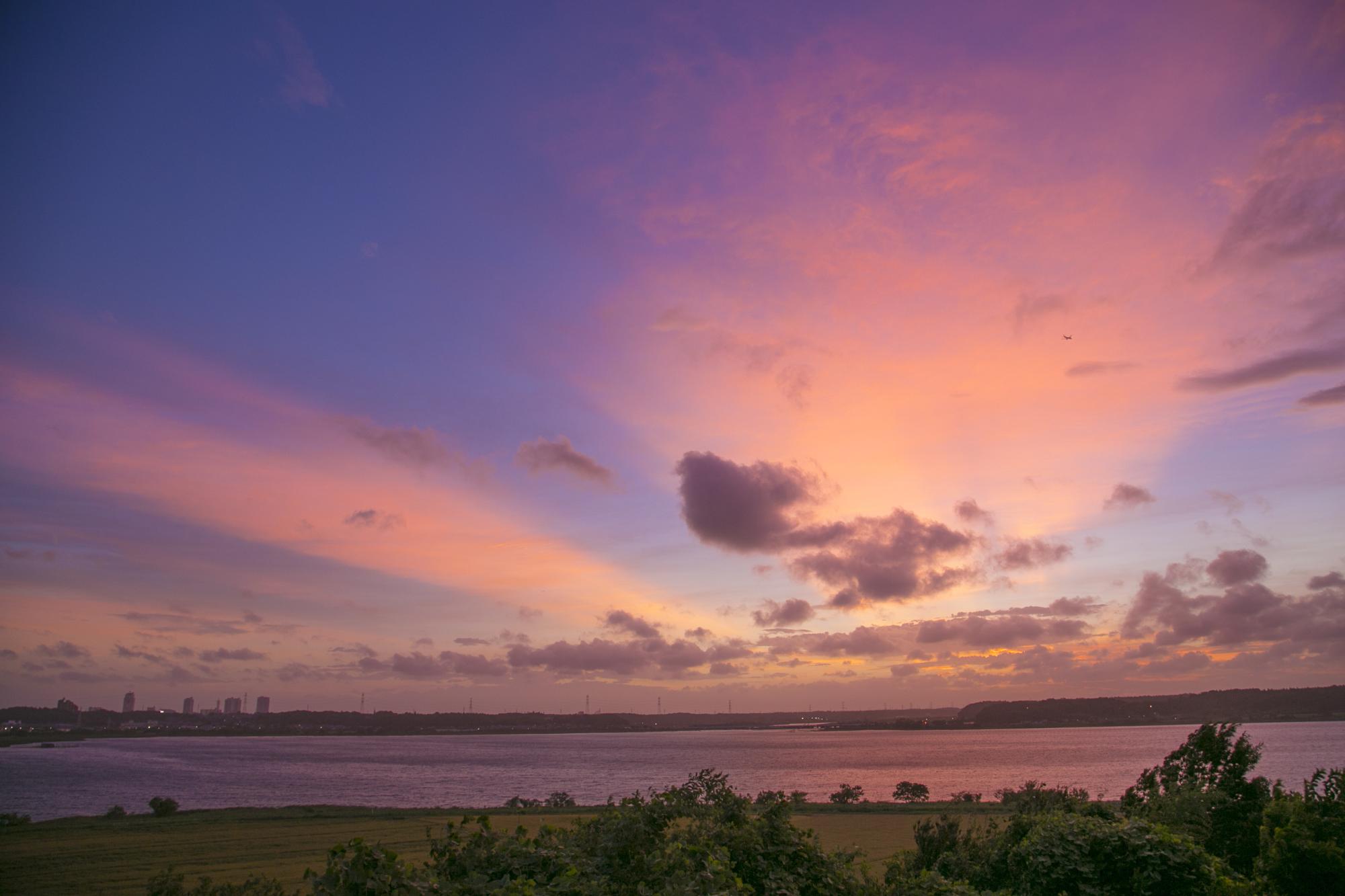 夕焼けの空が海面にも映ってうす紫に染まっている印旛沼サンセットヒルズの写真