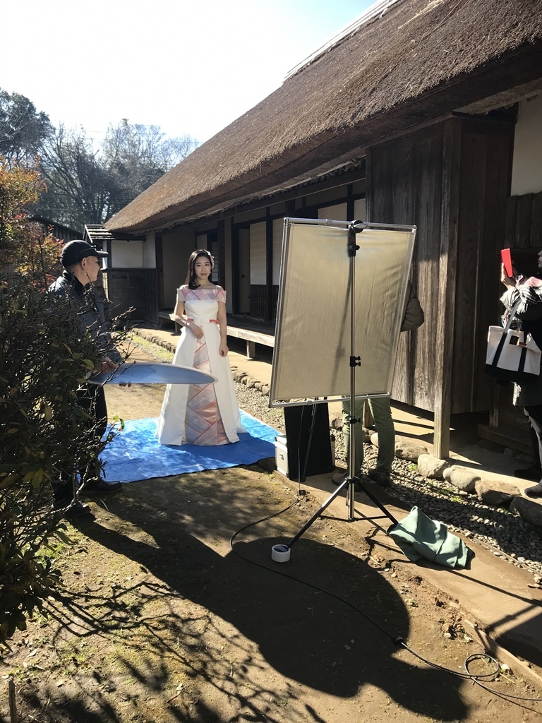 武家屋敷の庭に撮影機械がおかれ、ドレスを着た津吹みゆさんとスタッフの方が撮影をしている様子の写真