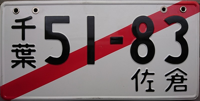 千葉51-83佐倉と書かれた、右上から左下にかけて赤い斜線の入っている白のナンバープレートの写真