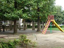 園内に生えている樹木の下にアスレチック、右手前にすべり台が設置されている御塚山もえぎ公園の写真