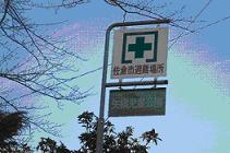 緑色の十字の記号と佐倉市避難場所、矢橋街区公園と書かれた案内板の写真