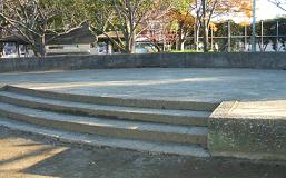円形の石で造られたステージがある御伊勢公園の写真