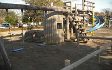 ブランコやすべり台がある木製の複合遊具が設置されている山王公園の写真