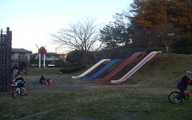小高い丘に4色のすべり台が並んで設置されている大福寺公園の写真