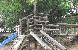 すべり台のある木製の複合遊具が設置されている長作東公園の写真
