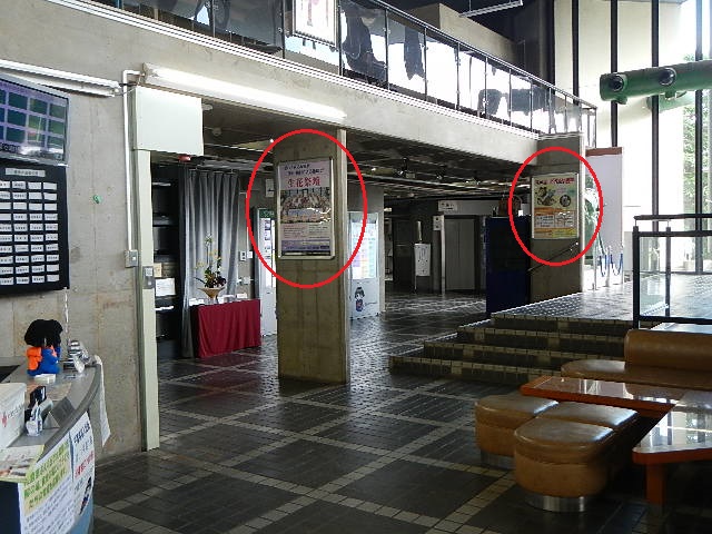 1号館ロビーの2カ所の柱に設置された広告の場所を赤い丸印で示した写真