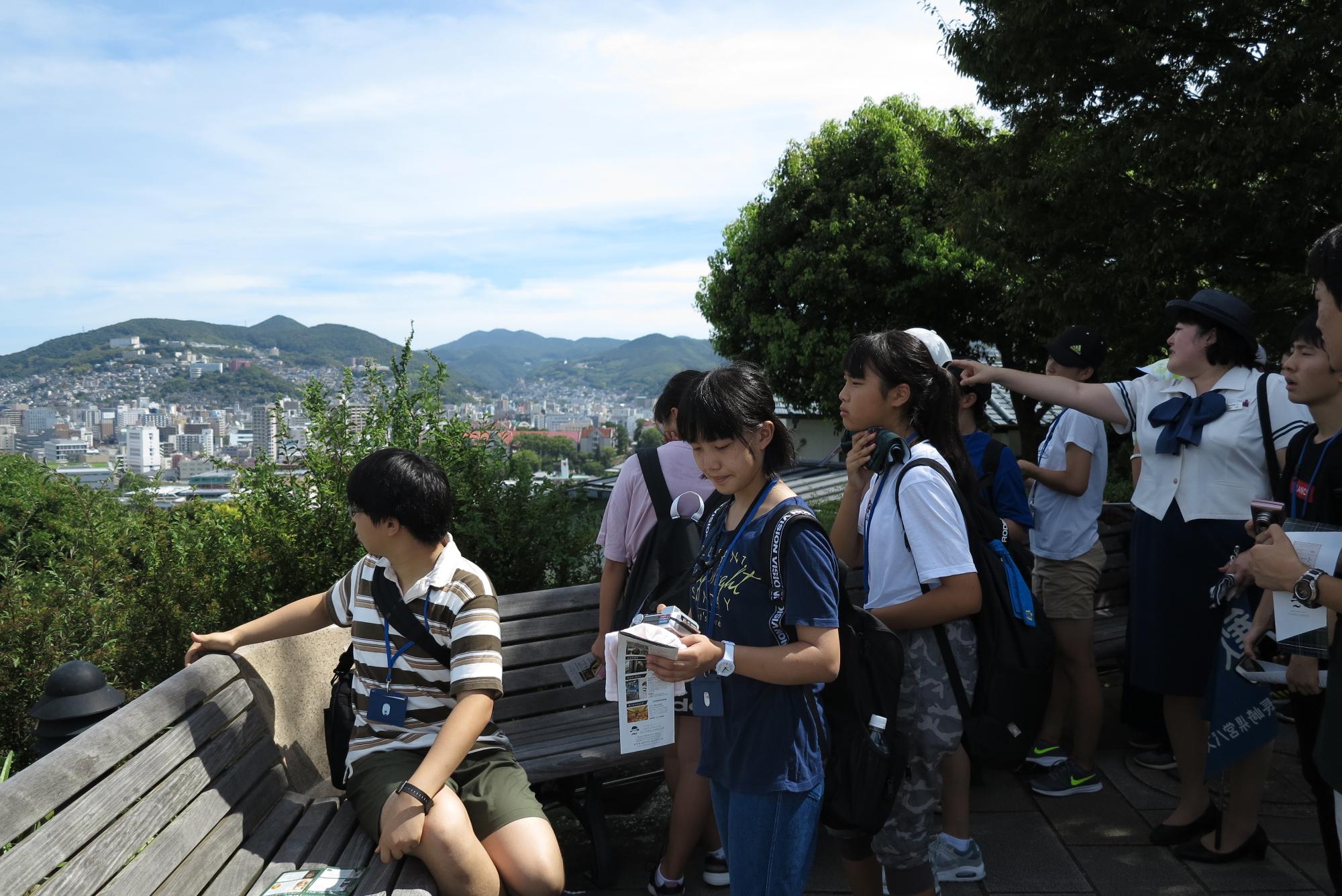生徒たちが奥に見える長崎市内の街並みを見ている写真
