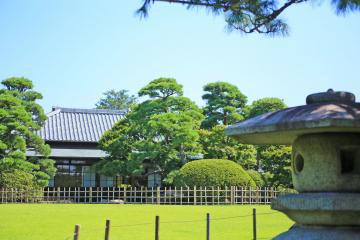 緑の芝生の庭園奥に建つ旧堀田邸の写真