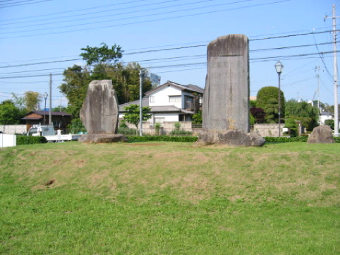 緑の芝生に建つ佐藤泰然と舜海の記念碑の全体を写した写真