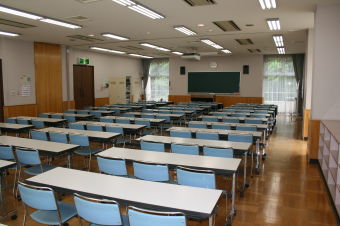 前方には黒板と講演台が設置され、3人掛けの長机が3列に前方から並んでいる広々とした学習室3の写真