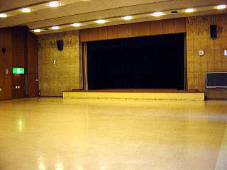 前方中央に舞台がある広々としたホールの写真