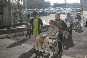 車椅子に乗っている市民カレッジ生、車椅子を押している市民カレッジ生が介護実習をしている様子の写真