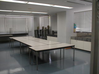 室内中央に作業机、窓際に流し台が設置されてある創作室の写真