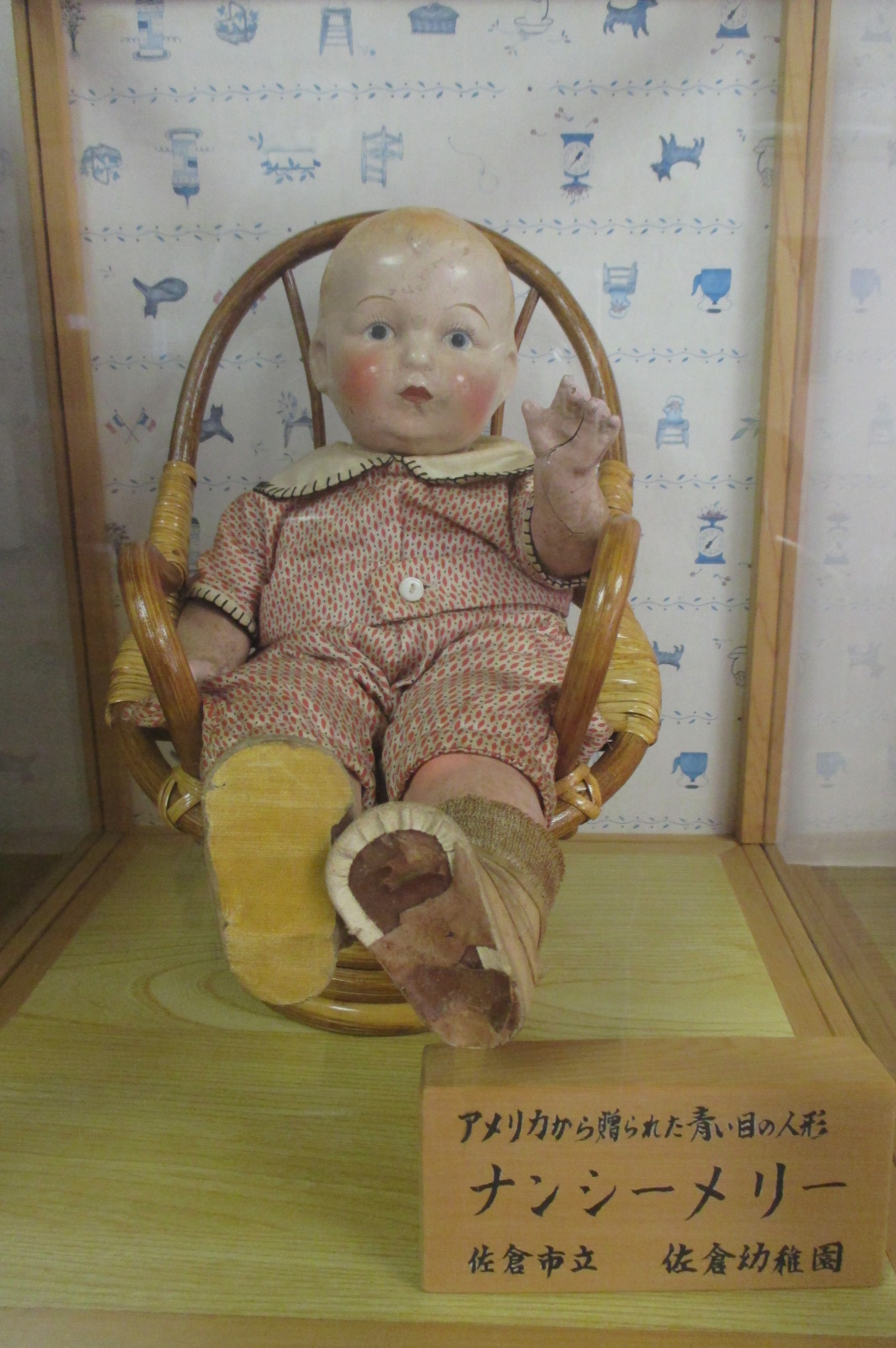 椅子に座っているナンシー・メリーの人形の写真