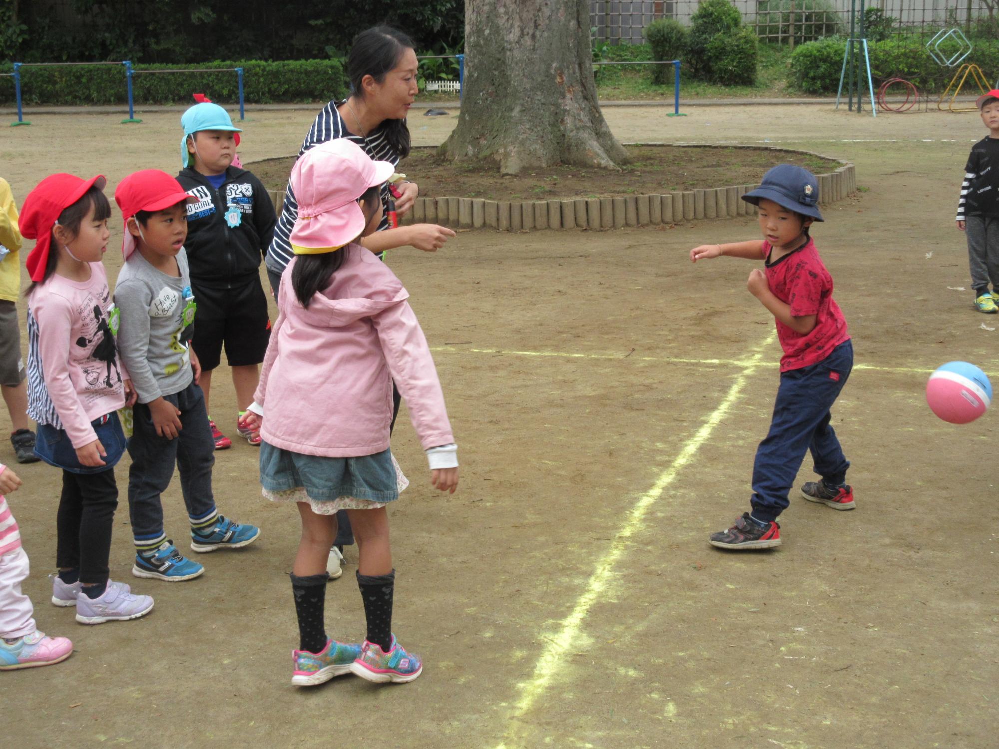 地面に黄色の線が引かれ、園児たちがドッジボールをしている写真