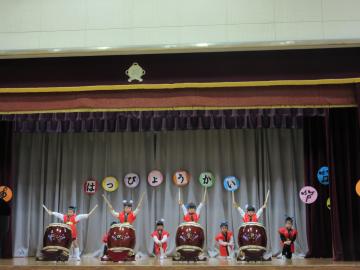 舞台の上で園児たちが和太鼓を演奏している写真