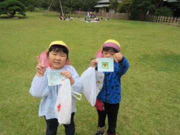 カラーキャップを被た園児2名が、シールを持ってピースサインをしている写真