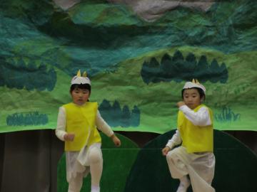 白地に黄色のやぎの衣装をきた園児2人が行進するように手をうごかしているオペレッタの写真