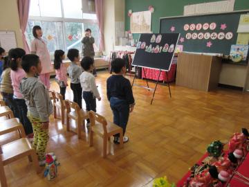 園児たちが椅子の前に立ち、歌を歌っている写真