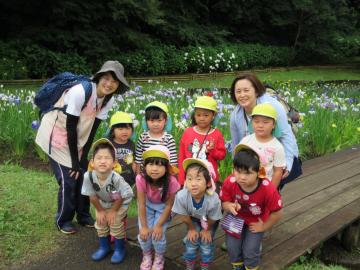 8名の園児と、女性2名が 花菖蒲をバックに並んでいる記念写真