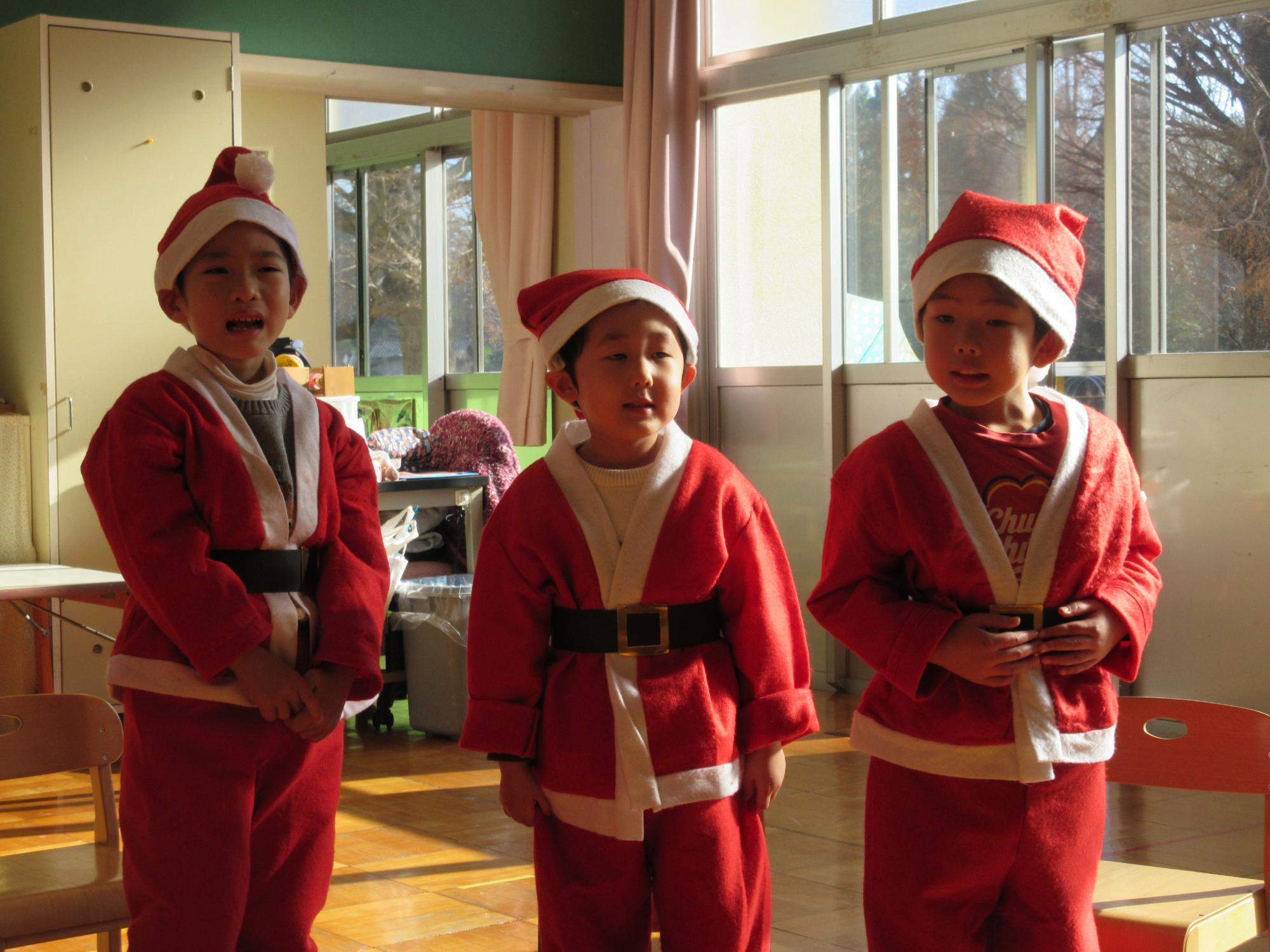 サンタクロースの衣装を着た3名の男の子の園児が並んでいる写真