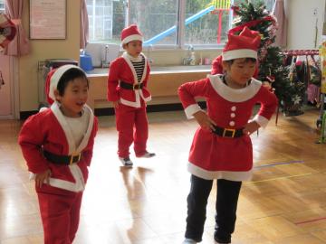 サンタの衣装を着た園児3名が踊りを踊っている写真
