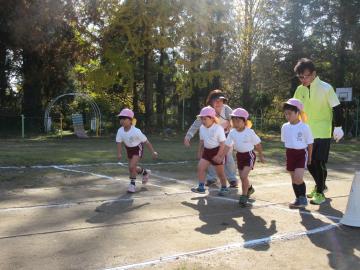 体育着を着た年少組の園児がスタート地点から走り始めている写真