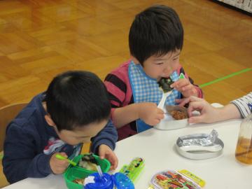 園開放に来ている小さな幼児2人がお餅を食べている写真