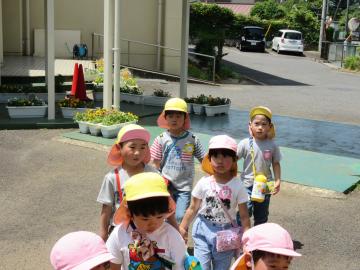 2名ずつ手を繋いで歩いている子供たちが幼稚園に到着した様子の写真