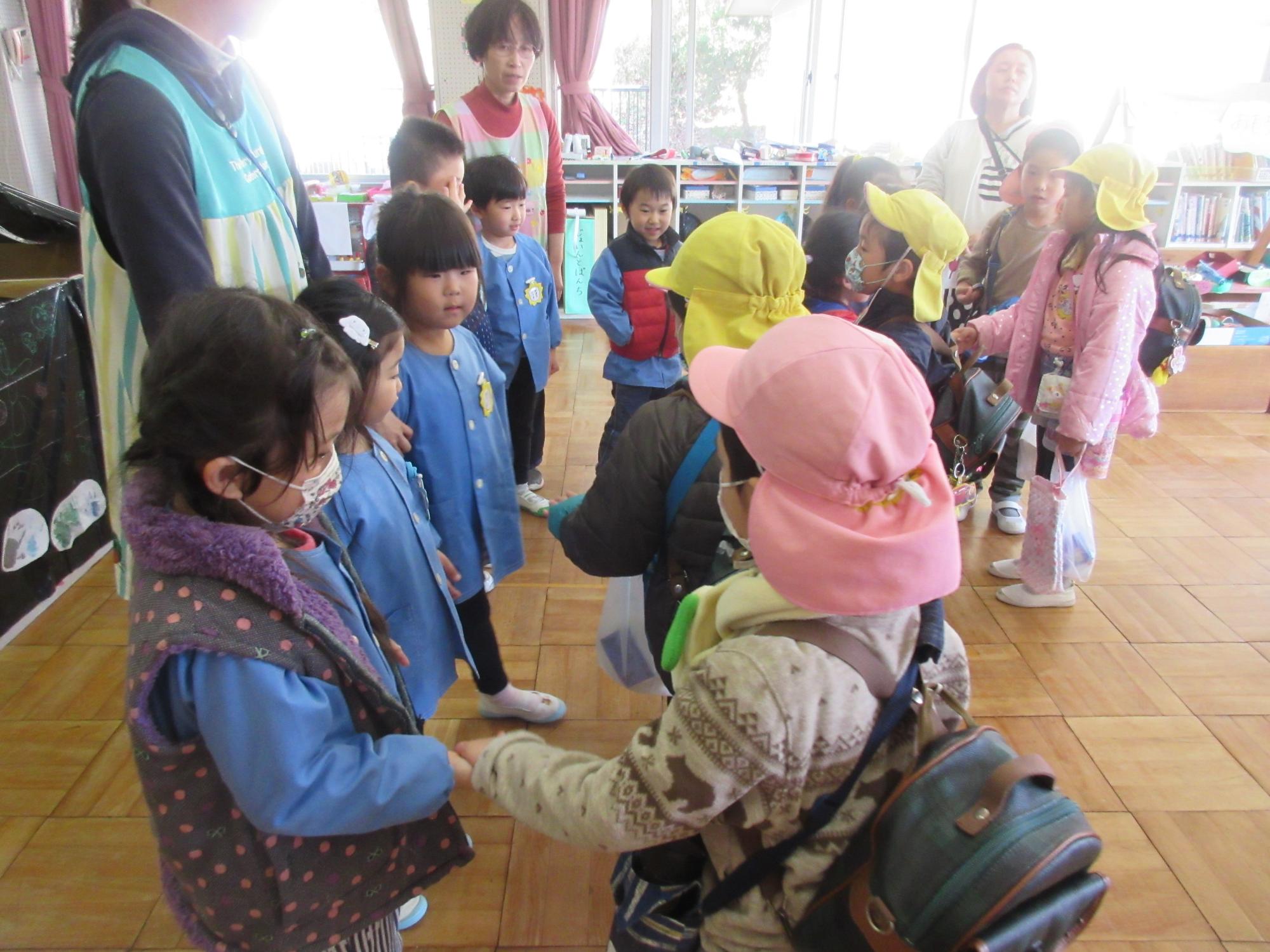 弥富幼稚園の園児と和田幼稚園の園児が握手をしてお別れをしている写真