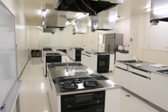 白を基調とした3台の調理台が2列に計6台並んでいる調理室の写真