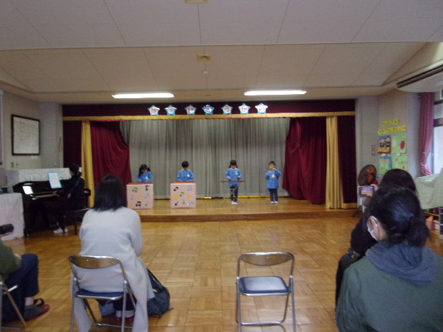 舞台の上で、合奏をしている4名の園児の写真