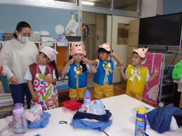 子豚の衣装と、エプロンに三角巾を付けた女の子が並んでいる写真