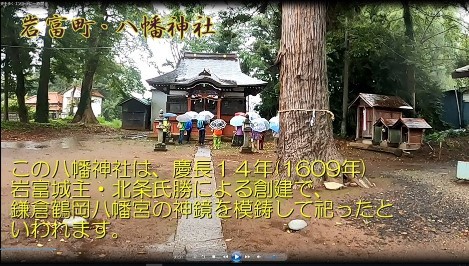 あたりを大きな木に囲まれた岩富町の八幡神社とその解説が書かれた写真：この八幡神社は、慶長14年(1609年)岩富城主・北条氏勝による創建で、鎌倉鶴岡八幡宮の神鏡を模鋳して祀ったといわれます。