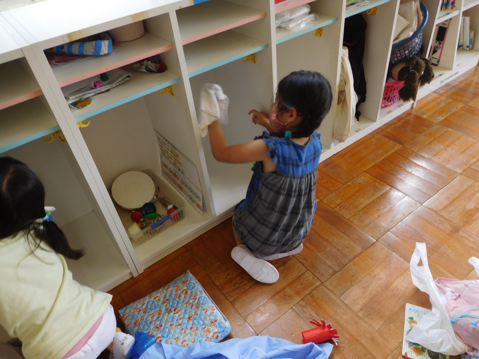 雑巾で棚の中を拭く女の子の園児の写真