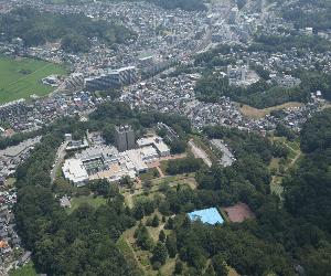 写真中央に佐倉城跡、その周りに緑の木々と佐倉市内の建物が映し出された空撮写真