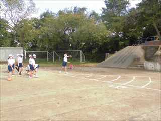 体力テストでラインが描かれた場所でボール投げをしている生徒たちの写真