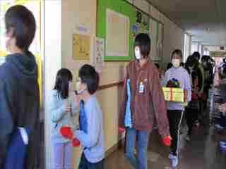 廊下を歩く6年生と他の学年の子どもたちの写真