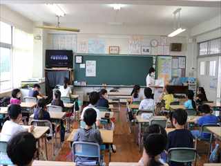教室のテレビで上映されているビデオを見ている生徒たちの写真