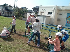 校庭に置かれた練習用具とその周りに集まって一輪車に乗る練習をしている生徒たちの様子の写真