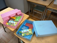 ピンクと空色のお道具箱に様々な勉強道具が入っている写真