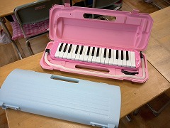 開いた状態のピンク色の鍵盤ハーモニカと閉じた状態の鍵盤ハーモニカの写真