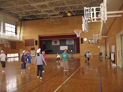 右上にバスケットボールのゴールがある下で子どもたちが遊んでいる写真