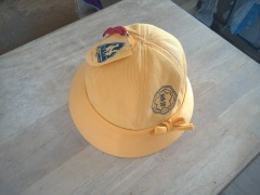 机の上に置かれた、学校指定の黄色の通学帽子の写真