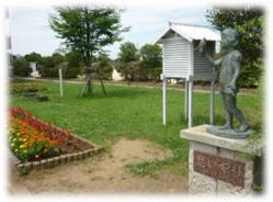 銅像と百葉箱が設置されている王子台小学校校庭の写真
