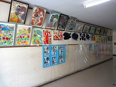 習字や図画作品が壁に並んで掲示されている様子の渡り廊下の写真