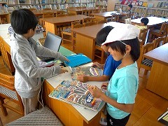 図書館で集まり、絵本を開く児童たちの写真