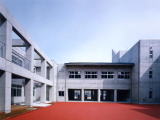 赤いラバーの地面で覆われた中庭と、それを囲むように建つ校舎の写真