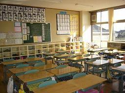 木製の机が規則正しく並べられている普通教室の写真